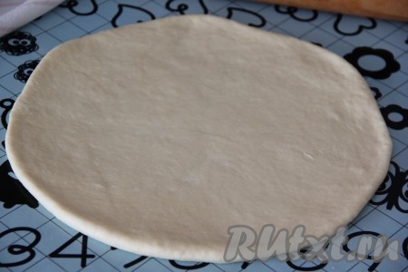 Готовое тесто разделить на 2 части. Одну часть теста раскатать с помощью скалки в нетонкий круг.