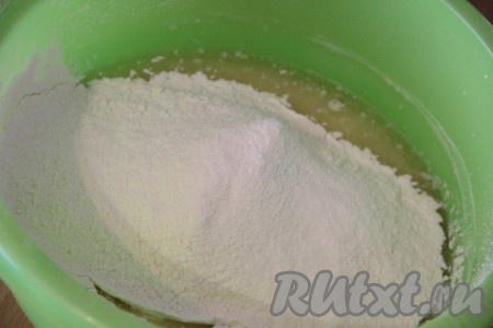 В получившуюся смесь добавить половину просеянной муки, перемешать столовой ложкой.