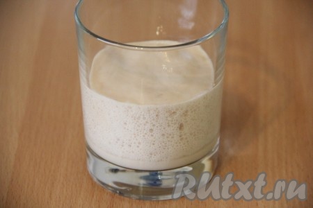 Замешивать дрожжевое тесто начнём с приготовления опары. Для этого в стакан нужно всыпать дрожжи, влить 50 миллилитров воды, подогретой до 38-40 градусов, и оставить минут на 10-15. По истечении этого времени на поверхности дрожжевой смеси появится пышная шапочка, означающая, что дрожжи начали работать.