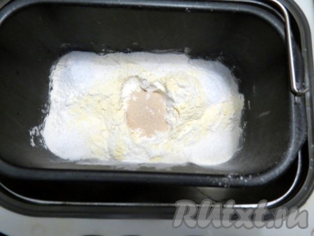 В центре муки сделайте углубление и всыпьте дрожжи.
