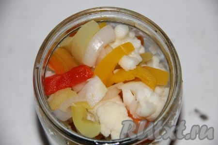 На дно&nbsp;стерилизованной баночки, выкладываем нарезанный на 4 части чеснок, перец горошком и все наши овощи.
