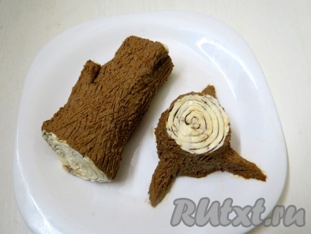 Торцовые части (срезы) смазываем мягким сливочным маслом, а вилкой наносим кольца. Ствол царапаем вилкой, имитируя кору дерева. Перекладываем сформированные бревно и пенёк на плоскую тарелку.