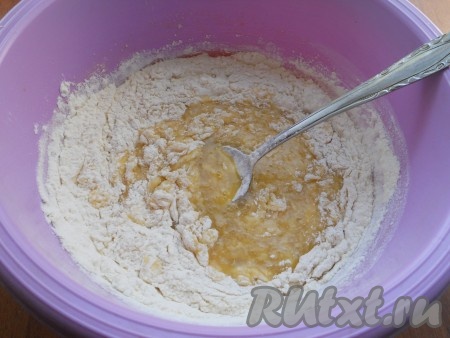 Частями начать добавлять просеянную муку, вначале перемешивая песочное тесто столовой ложкой.
