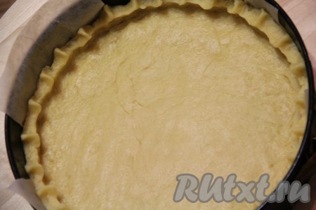 Готовое тесто разделить на две части: одна часть (побольше) - для основы, другая часть теста послужит украшением верхушки пирога. Форму для пирога лучше взять разъёмную, я выложила дно и бока формы пергаментом. Тесто для основы выложить в форму и разровнять по всей поверхности, сформировать бортик.
