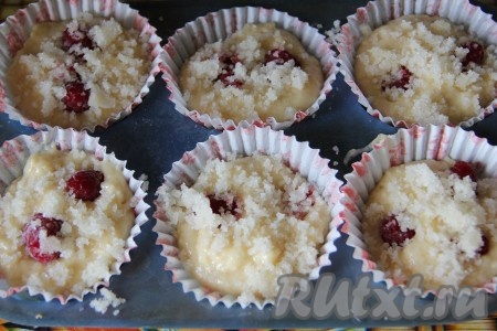 Смазать формочки растительным или сливочным маслом. Если готовите в бумажных или силиконовых формах, то смазывать не нужно. Разложить массу, заполняя формочки на 2/3, добавить ягоды прямо в формочки и сверху присыпать крошкой.&nbsp;&nbsp;
