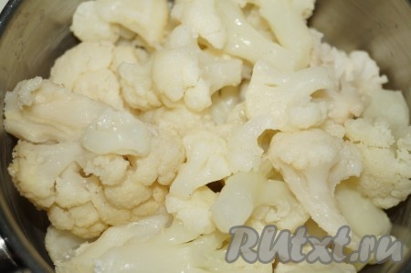 Цветную капусту, разобранную на соцветия, залить водой, поставить на огонь, довести до кипения, посолить и варить минут 7-10 с момента закипания. Готовую капусту откинуть на дуршлаг, чтобы убрать лишнюю воду, остудить и мелко нарезать.
