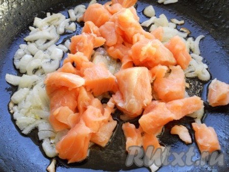 Репчатый лук очистить, нарезать и обжарить на смеси растительного и сливочного масел до мягкости, иногда помешивая. Добавить в сковороду кусочки семги. Обжарить всё вместе до изменения цвета рыбы (минуты 3-4). Посолить.
