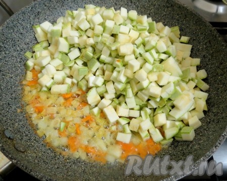 К луку и моркови добавляем кабачки и муку, хорошо перемешиваем. Обжариваем кабачки, не забывая помешивать, до слегка золотистого цвета. Во время жарки сковороду крышкой не накрываем. Тщательно промытый рис и обжаренные кабачки отправляем в готовый овощной бульон, доводим до кипения, огонь убавляем и варим до готовности риса, примерно 20 минут.
