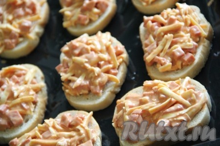  Выложить на поверхность хлеба колбасно-сырную массу и слегка разровнять.