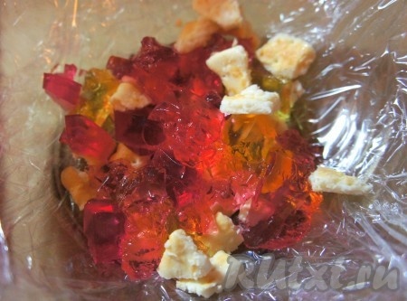 Глубокое блюдо застелить пищевой плёнкой, выкладывать слоями печенье, желе, крем