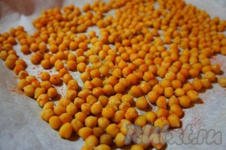 Противень застелить пергаментной бумагой, сбрызнуть маслом, высыпать вареный нут. Добавить специи, соль.