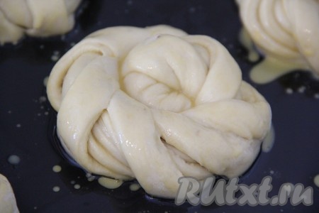 Яичный желток слегка взбить с молоком. Смазать желтком поверхность булочек, поставить противень в разогретую духовку и выпекать при 200 градусах примерно 25 минут.
