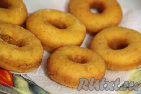 Готовые тыквенные пончики выкладывать на бумажное полотенце, чтобы убрать излишки масла. Постепенно пожарить все пончики.