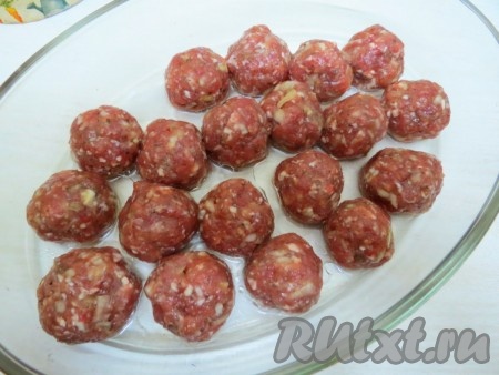 Из фарша мокрыми руками скатываем фрикадельки размером с большой грецкий орех. На дно формы для запекания выливаем 2 столовых ложки растительного масла и 100 миллилитров воды, выкладываем фрикадельки, накрываем форму фольгой и отправляем в разогретую духовку. Запекаем фрикадельки 20 минут при температуре 200 градусов. Затем фольгу убираем и запекаем ещё 10 минут без фольги, чтобы фрикадельки слегка зарумянились, а внутри остались сочными.