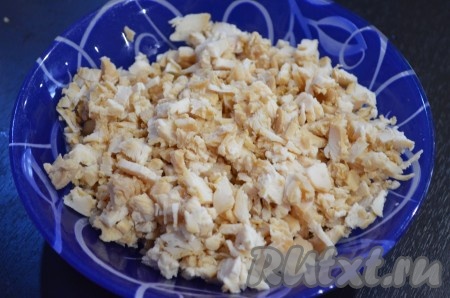 Куриное мясо (можно взять филе, голени или бёдра) вымыть, поместить в кастрюлю, залить полностью водой и поставить на огонь, после закипания посолить и варить 25-30 минут на небольшом огне. Варёное мясо полностью остудить, затем отделить от костей. 250 грамм куриного мяса без костей мелко нарезать, сложить в миску.