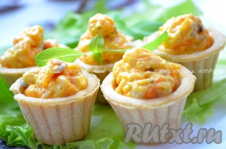 Выложить готовые тарталетки с селедочной начинкой на тарелку (можно на листья салата, так красивее). Охладить и можно подавать к праздничному столу. Тарталетки с селедкой получаются очень вкусными и яркими.

