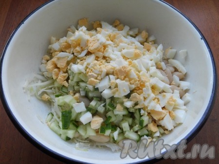 Яйца отварить, залить холодной водой, дать остыть. Очистить и нарезать небольшими кусочками. Огурец свежий нарезать маленькими кубиками. Добавить яйца и огурец в салат к капусте с фасолью.
