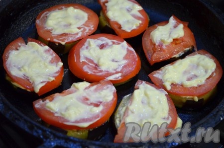 Помидор нарезать на не очень тонкие кружочки. На смазанные кружочки баклажанов выложить кружочки помидоров, тоже смазать смесью майонеза и чеснока.
