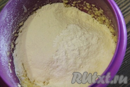 Цедру лимона в эту выпечку можно не добавлять. Но мне захотелось сделать печенье более ароматным и я решила добавить цедру. Поэтому с хорошо вымытого лимона сняла, примерно, 1 чайную ложку цедры. Снимая с лимона цедру, старайтесь не затрагивать, находящийся под ней белый слой. Добавить цедру в яично-масляную смесь, перемешать миксером. Затем всыпать разрыхлитель и половину муки, перемешать тесто на низкой скорости миксера.