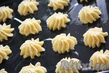 Противень для выпечки смазать растительным маслом. Тесто переложить в кондитерский мешок и с помощью фигурной насадки отсадить его на противень. Можно просто выложить тесто при помощи столовой ложки.