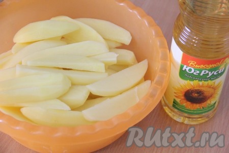 Картошку нарезать на длинные дольки. Выложить нарезанный картофель в удобную миску, добавить 3 столовых ложки растительного масла, посолить по вкусу. Хорошо перемешать, чтобы дольки картошки полностью покрылись маслом.