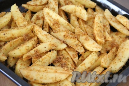 Всыпать панировочные сухари со специями в миску с картошкой, аккуратно перемешать. Противень смазать маслом, затем выложить картофель в один слой.