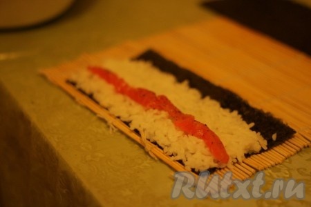 Формируем роллы. Выкладываем на нори тонкий слой риса и сверху рыбу.