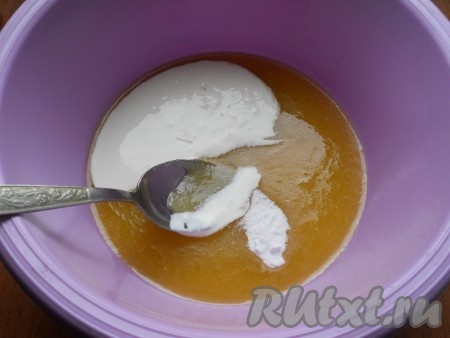 В слегка остывшую смесь добавить сметану и соду, перемешать ложкой до однородности.