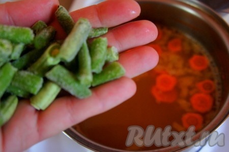 Добавить в бульон стручковую фасоль, перемешать, варить 3 минуты.