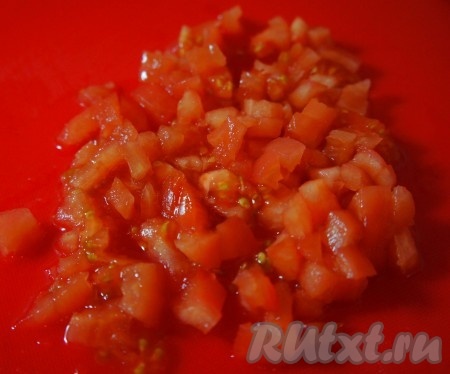 Помидор надрезать, опустить в кипяток на 2-3 минуты. Снять кожуру. Нарезать мелкими кубиками, добавить в суп. Варить 2 минуты.
