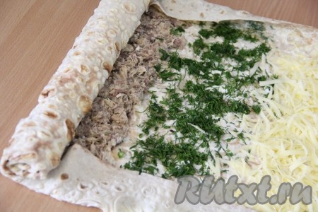 Аккуратно завернуть края лаваша на начинку, а затем свернуть лаваш с начинкой в тугой рулет.