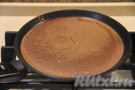 Сковороду смазать маслом только перед первым блином, последующие блинчики хорошо переворачиваются, поэтому маслом сковородку можно не смазывать (впрочем, многое зависит от качества сковороды). Поставить сковороду на огонь, дать ей хорошо разогреться. На раскалившуюся сковороду вылить пару столовых ложек теста и хорошо распределить по дну сковороды. Выпекать шоколадный блинчик на среднем огне с двух сторон, затем переложить на тарелку. Периодически перемешивая блинное тесто, постепенно пожарить все блины, складывая их один на другой на тарелку.