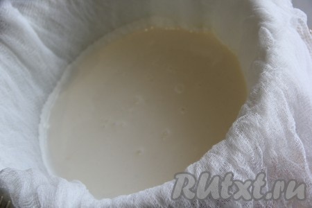 Дуршлаг выстелить марлей, сложенной в два раза. Аккуратно перелить смесь из кефира и сметаны в дуршлаг.