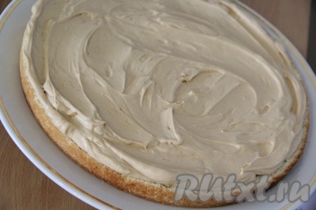 Выложить крем на корж и разровнять его по всей поверхности.