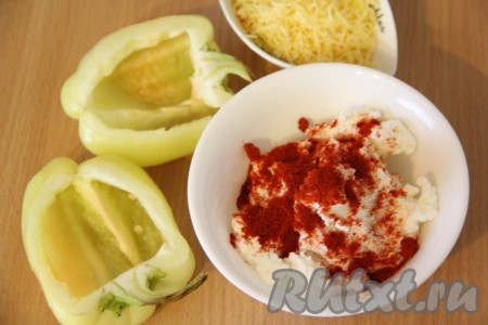 Перец вымыть, разрезать пополам и удалить семена. Плодоножку желательно оставить. У нас получилось две лодочки. В творог добавить соль и паприку. Тщательно перемешать творог со специями.
