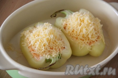 Выложить перцы в жаропрочную форму. На дно формы налить немного воды. Поверх перцев посыпать натёртым сыром. Сыра не жалеем, он растопится и пропитает наши перчики ароматом и сырным вкусом.
