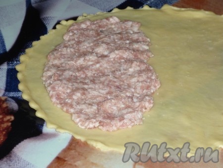 На половину теста выложить часть фарша, немного отступив от края.