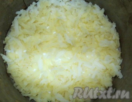 Начинаем сборку салата. Я делала салат в разъёмной форме для выпечки торта, но вы можете просто последовательно выкладывать слои на тарелке. Дно формы или тарелки смазываем майонезом. Сверху натираем половину картофеля, слегка солим, перчим. Половину хрена, отжатого от маринада, выкладываем на картошку.