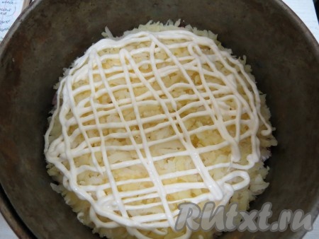 На колбасу выкладываем лук, оставшийся картофель, слегка солим, перчим, добавляем оставшийся отжатый от маринада хрен, делаем сеточку из майонеза.
