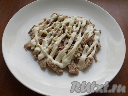 Мясо отварить в подсоленной воде до готовности, остудить. Сварить свеклу, морковь и яйца. Остудить все продукты и очистить. Мясо (у меня - свинина) нарезать небольшими брусочками, смешать с измельченным чесноком и поместить на блюдо первым слоем. Смазать майонезом.
