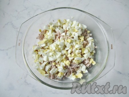 Яйца сварить вкрутую (то есть в течение 10 минут после закипания воды), полностью остудить их, очистить. Мелко нарезать яйца и выложить в миску с салатом из куриной грудки и кальмаров. 