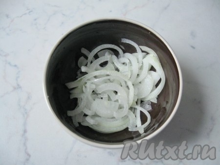 Репчатый лук почистить, помыть, нарезать полукольцами, переложить в небольшую глубокую ёмкость, добавить сахар и уксус, перемешать и оставить мариновать на 15-20 минут. Несколько раз за это время нужно перемешать, чтобы лук равномерно промариновался.