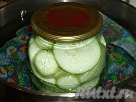 Для стерилизации налить в кастрюлю горячую воду, чтобы она доходила до "плечиков" банок, положить на дно кастрюли полотенце (это нужно для того, чтобы&nbsp;наши банки при кипении в кастрюле не лопнули). В кастрюлю поверх полотенца поставить банки с кабачками, сверху прикрытые крышками. Довести воду в кастрюле на среднем огне до кипения и простерилизовать банки с кабачками (продолжительность стерилизации зависит от размеров банок: литровые банки стерилизовать 10-13 минут, пол-литровые банки - 7 минут).
