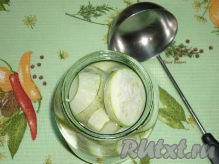 Приготовить маринад для кабачков: в воду насыпать соль и сахар, поставить маринад на огонь, довести его до кипения, а затем проварить на среднем огне до полного растворения соли и сахара, затем добавить уксус. Осторожно залить банки с подготовленными кабачками горячим маринадом до самого верха, накрыть прокипячёнными крышками и поставить стерилизоваться.
