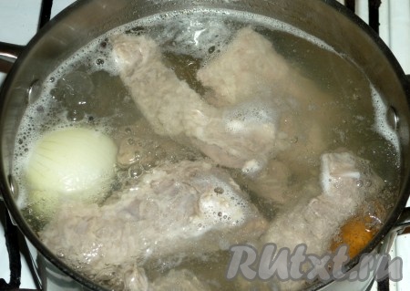 В кастрюлю с кипящей водой опустить рёбрышки, добавить очищенные лук, морковь, соль и горошины перца. После закипания проварить мясо на небольшом огне 10 минут.&nbsp;