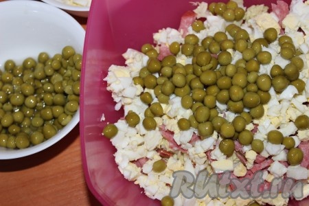 Открыть банку с консервированным горошком. Жидкость слить, горошек добавить в салат.&nbsp;

