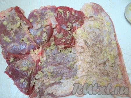 Мясо обильно смазываем выдавленным через пресс чесноком, солим и перчим.
