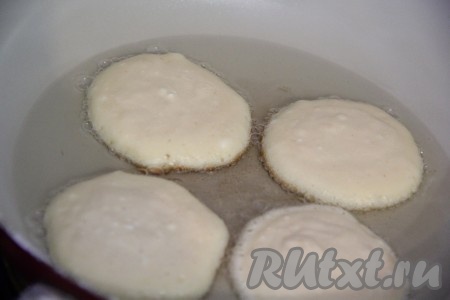 В сковороду влить растительное масло и поставить на огонь. Я при выпекании оладий масла не жалею, просто в последующем выкладываю оладьи на бумажное полотенце, тем самым избавляюсь от лишнего жира. Выложить в разогретую сковороду по 1 столовой ложке теста. 