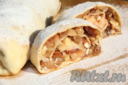 Поставить в разогретую духовку и выпекать при 180-200 градусах примерно 30 минут, до лёгкой золотистой корочки. Готовый штрудель с яблоками и орехами слегка остудить, затем переложить на плоскую тарелку и нарезать на порции. При подаче щедро посыпать сахарной пудрой или полить сиропом.&nbsp;
