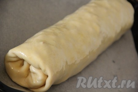 Противень для выпекания застелить пергаментом. Выложить штрудель на противень и смазать его растопленным сливочным маслом.
